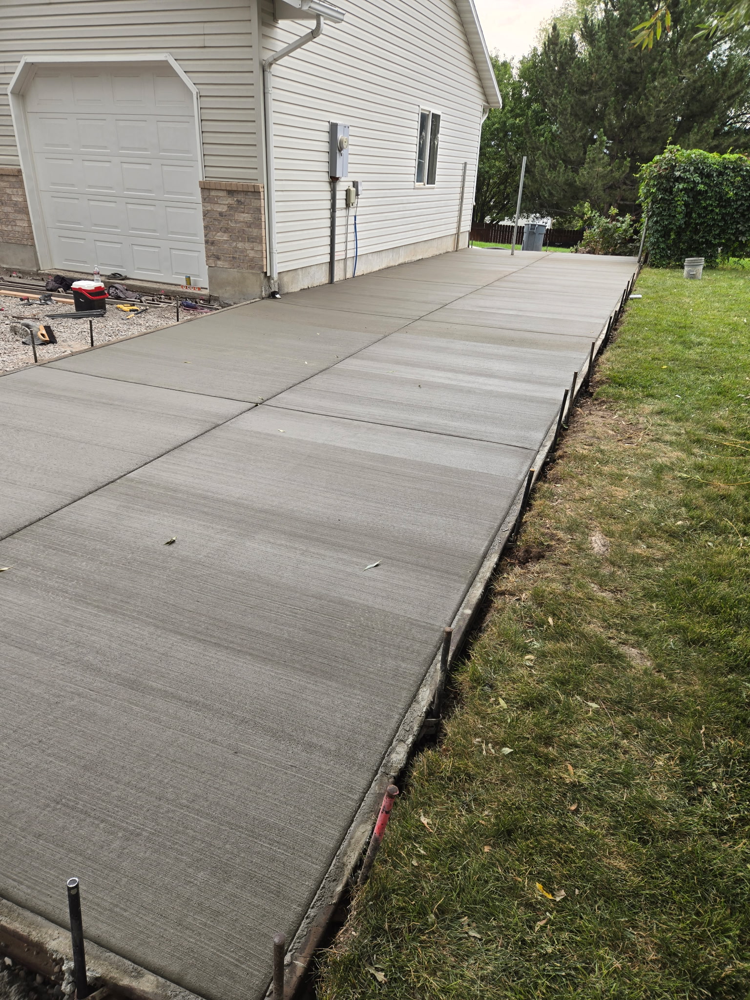 Freshly poured concrete driveway alongside house